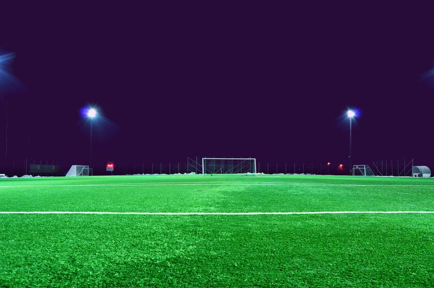 Lapangan sepak bola hijau dengan cahaya stadion